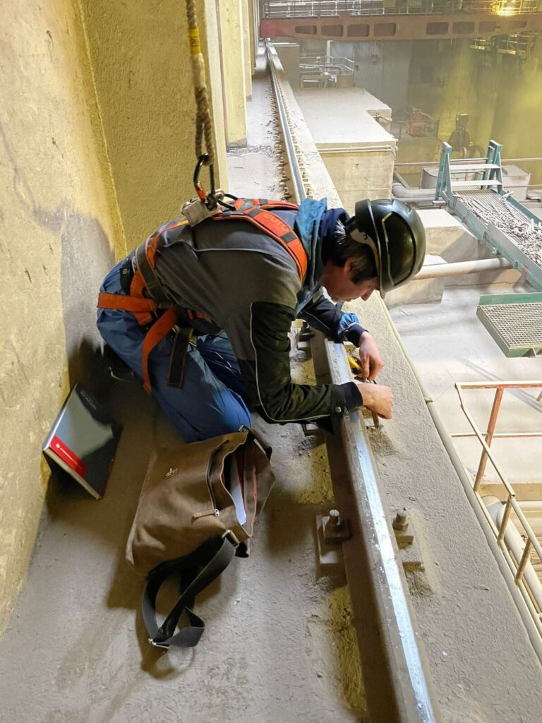 Monteur mit Absturzsicherung an der Kranschiene der MVA Flötzersteig