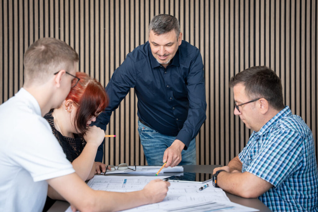 Team von PE Solutions bespricht eine Anlagenplanung am Besprechungstisch